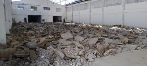 Demolição de piso industrial em galpão logístico durante obra acompanhada por engenheiro civil